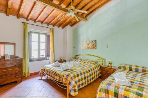 a bedroom with two beds and a ceiling fan at Agriturismo Girasole in Gambassi Terme