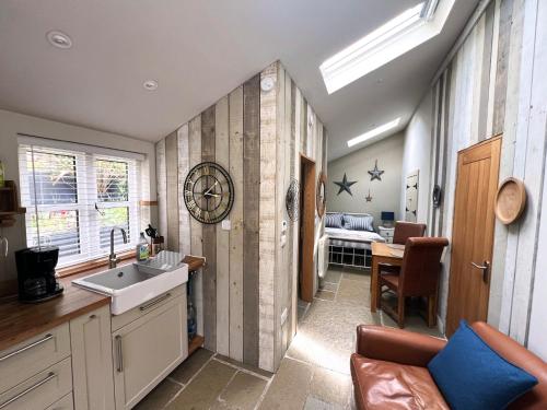 a kitchen with a sink and a clock on the wall at The Leat at The Old Mill in Tavistock
