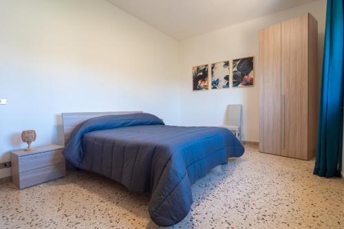a bedroom with a blue bed and a wooden cabinet at Suliventumari in Ribera