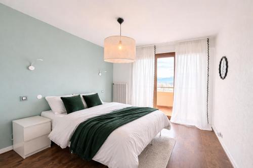 a white bedroom with a large bed and a window at M046 T3 cosy 2 chambres et balcon in Ambilly