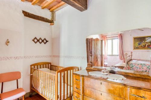 a room with two cribs and a dresser with a mirror at Agriturismo Girasole in Gambassi Terme