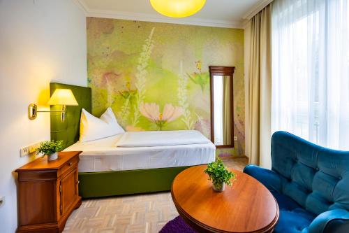 a hotel room with a bed and a couch at Hotel Allmer in Bad Gleichenberg