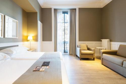 a hotel room with a bed and a couch at Hotel Granvia in Barcelona