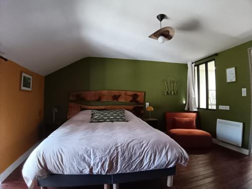 a green bedroom with a bed and a chair at la demeure des songes in Josselin