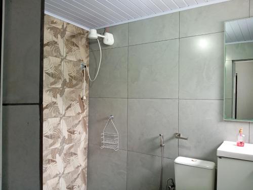 a bathroom with a shower with a toilet and a sink at Quarto casal in Itaqui