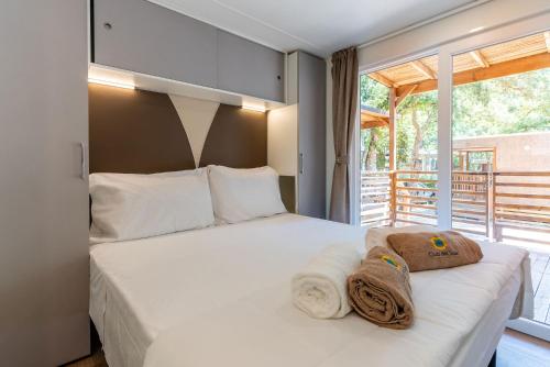 a bedroom with a bed with towels on it at Club del Sole Stella del Mare Family Collection in Castiglione della Pescaia