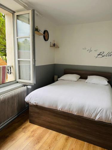 a bed in a bedroom with a large window at Relais Saint-Laurent - Chevreuse in Chevreuse