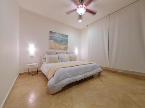 1 dormitorio blanco con 1 cama y ventilador de techo en Charming 2BR condo in quiet surroundings by Happy Address, en Playa del Carmen