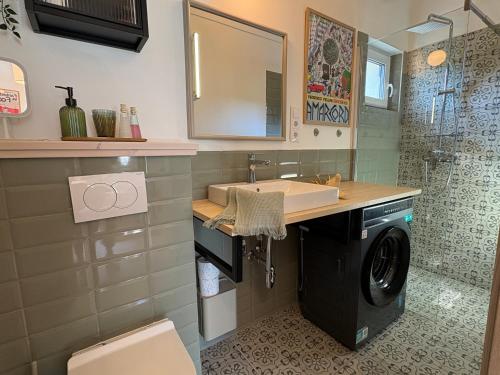 a bathroom with a sink and a washing machine at ZadorHomes Etyek in Etyek
