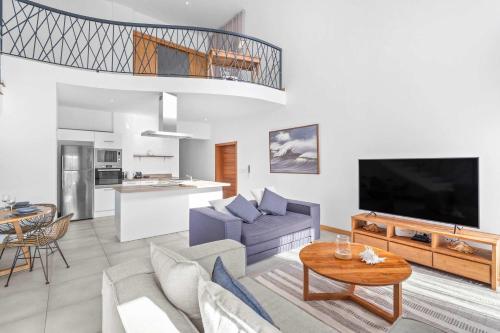 a living room with a couch and a table at Golden Bloom - High-End Duplex w Private Pool in Rivière Noire