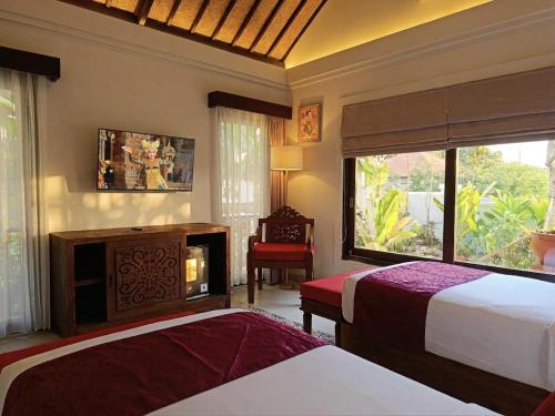 a hotel room with two beds and a fireplace at Sardja Uluwatu in Uluwatu