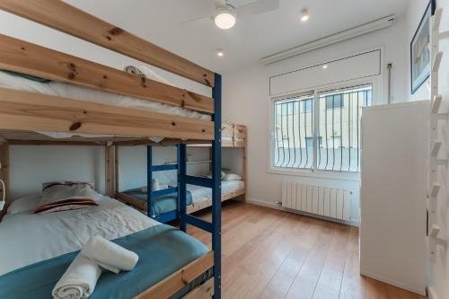 a bedroom with two bunk beds and a window at Beach Villa Cristina by HHBCN in Castelldefels