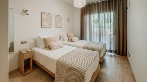 a bedroom with two beds and a window at Alta de Faro in Faro