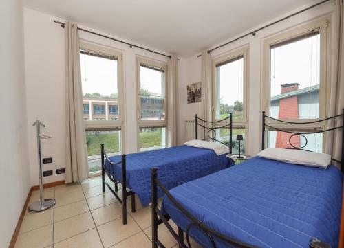two beds in a room with windows at Casa Vacanza Ninfea in Paratico
