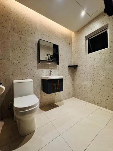 a bathroom with a toilet and a mirror on the wall at uncommon homestay in Klang