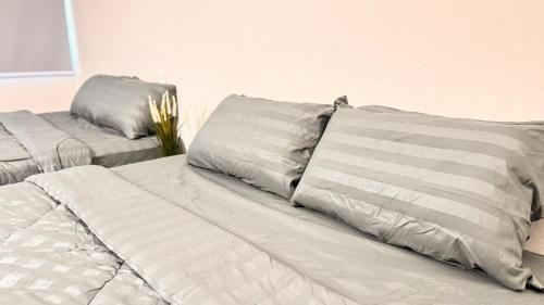 a white bed with two pillows on top of it at uncommon homestay in Klang