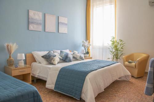 a blue bedroom with a bed and a chair at Actinia Accommodation in Alghero