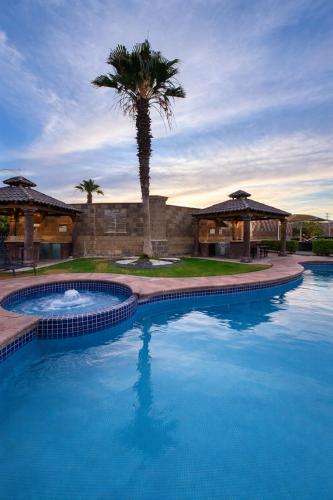 a large swimming pool with a palm tree in front of a building at Arroyos del Paraíso Residencial Suite C in Manuel F. Martínez