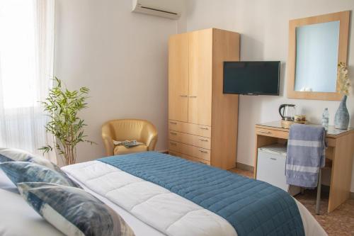 a bedroom with a bed and a desk with a computer at Actinia Accommodation in Alghero