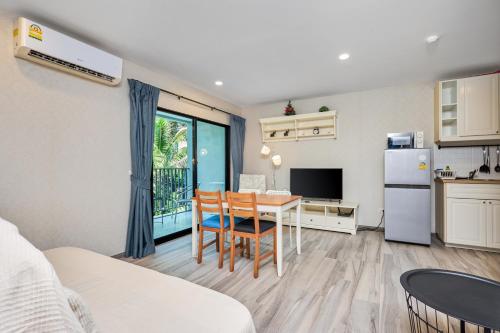 a kitchen and living room with a table and a refrigerator at NaiYang beach Title Residencies by My Home Phuket in Nai Yang Beach