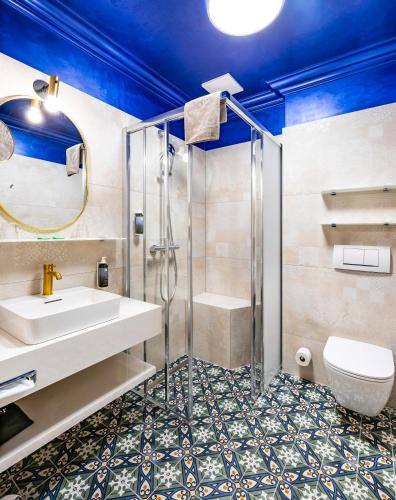 a bathroom with a shower and a sink and a toilet at Hotel Allmer in Bad Gleichenberg