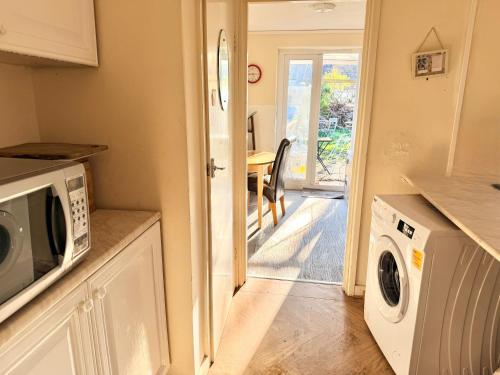 a kitchen with a washer and dryer next to a door at Central Reading Cozy Spacious Room in Reading