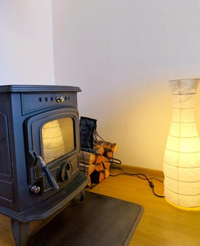a room with a stove and a lamp and a vase at Studio, Fireplace, Super location, Free Parking in Tallinn