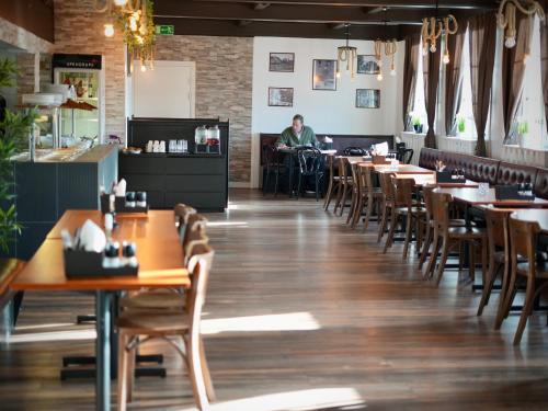 a man sitting at a table in a restaurant at Järnvägshotellet Charlottenberg in Charlottenberg