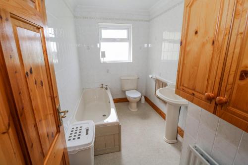 a bathroom with a tub and a toilet and a sink at Castle View in Oughterard