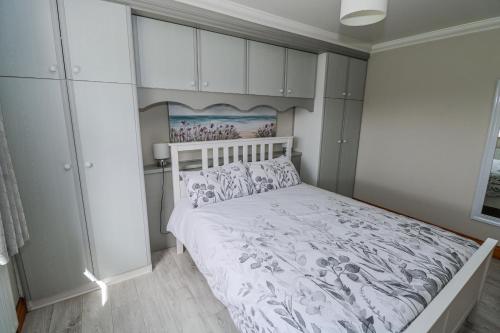 a bedroom with a white bed and white cabinets at Castle View in Oughterard