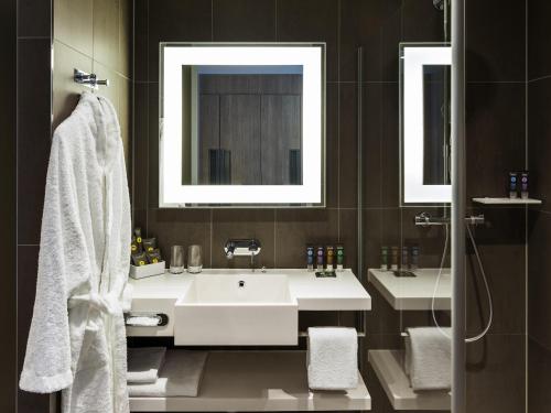 a bathroom with two sinks and a mirror at Novotel Amsterdam Schiphol Airport in Hoofddorp