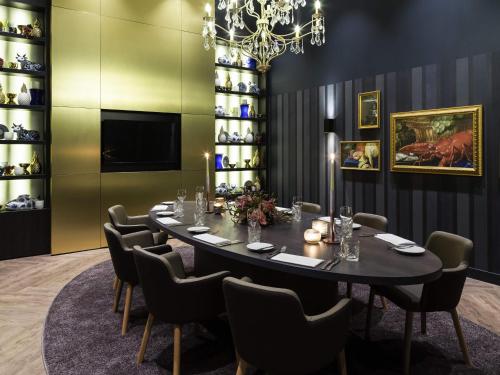 a dining room with a table and chairs and a chandelier at Novotel Amsterdam Schiphol Airport in Hoofddorp