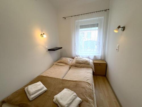 two beds in a small room with a window at Erika Vendégház in Igal