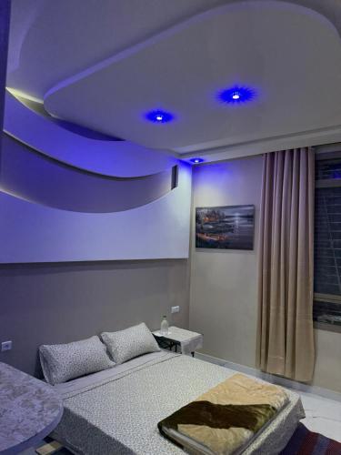 a bedroom with a bed and a blue ceiling at Comfort House in Azib Aïn el Alak