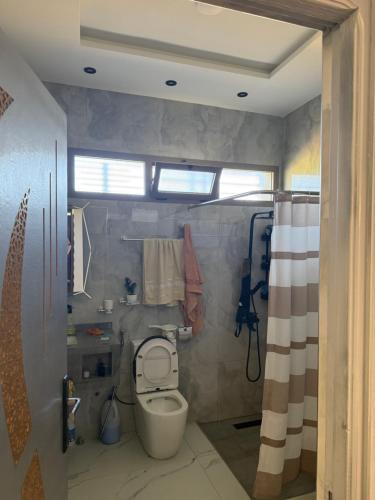 a bathroom with a toilet and a shower at Comfort House in Azib Aïn el Alak