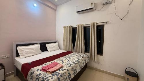 a bedroom with a bed and a window at Utkarsh Palace And Restaurant in Ayodhya Ghā