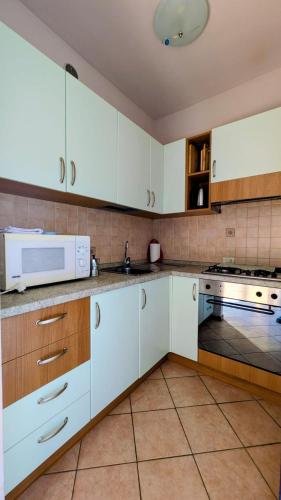 a kitchen with white cabinets and a microwave at Bosco Di Lago in Solto Collina