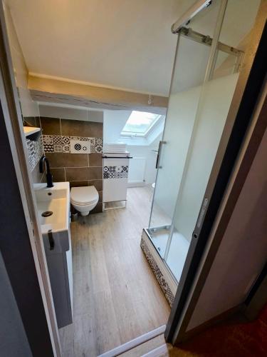 a small bathroom with a toilet and a glass door at Relais Saint-Laurent - Chevreuse in Chevreuse