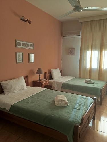 a bedroom with two beds and a window at IZEΛA Hotel in Kala Nera