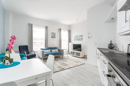 a kitchen and living room with a table and chairs at Walled City Apartments in Derry Londonderry