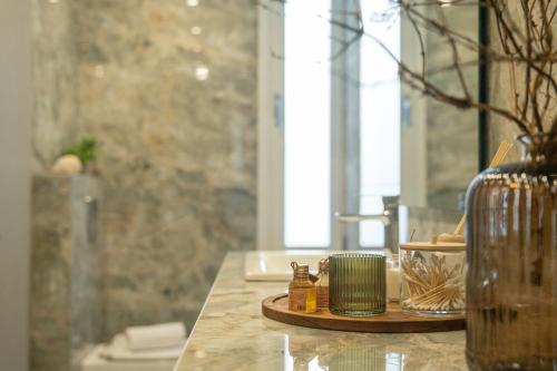a bathroom counter with a sink and a vase at Agora Luxury Suites in Lixouri