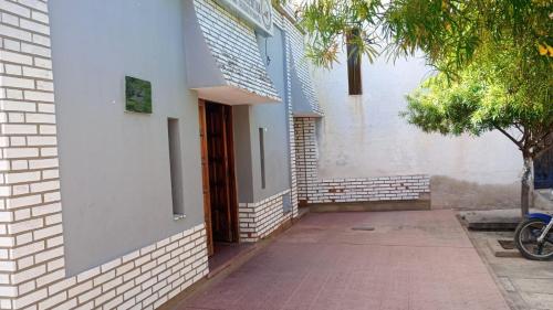 an open door of a building with a sidewalk at Posada el circulo in Chamical