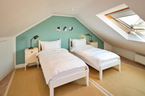 two beds in a attic room with a roof at Finest Retreats - Mill Barn By The Stream in West Lydford