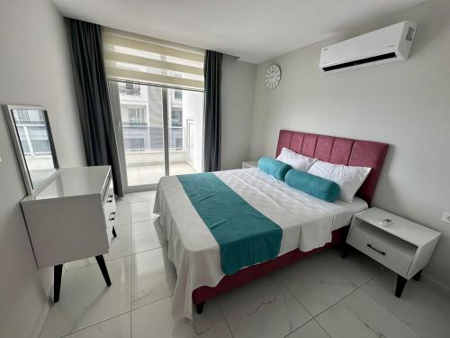 a bedroom with a bed and a desk and a window at ARCADIA Homes in Alanya