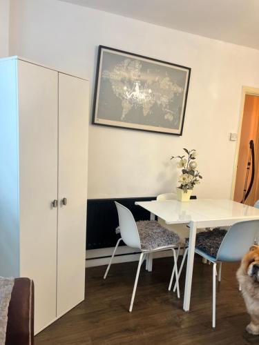 a dining room with a white table and chairs at Spacious apartment - 1 fluffy dog lives on site in Brighton & Hove