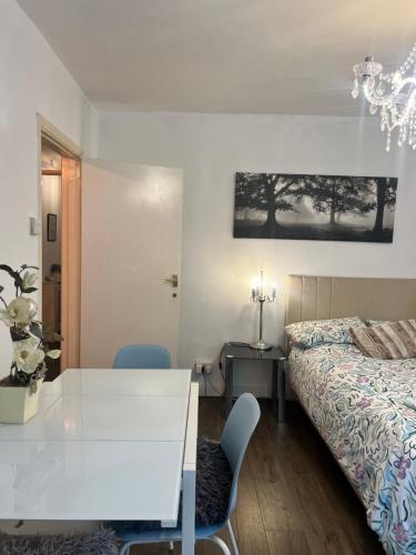 a bedroom with a bed and a table and chairs at Spacious apartment - 1 fluffy dog lives on site in Brighton & Hove