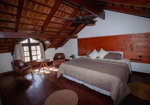 a bedroom with a large bed and a ceiling at Finca La Marta - El Cortijo Wine Lodge in Capilla del Monte