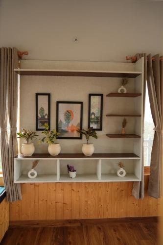 a shelf with potted plants on it in a room at The Windbloom - Himalayan Farm Stay in Mukteshwar