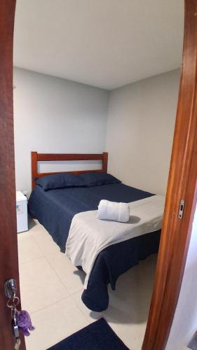 a bedroom with a bed with blue and white sheets at Chalé Lá Aurora in Guaramiranga