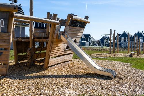 a playground with a slide in a park at Ferienhaus Nordseeresort 55 Meerglück Büsum in Büsum